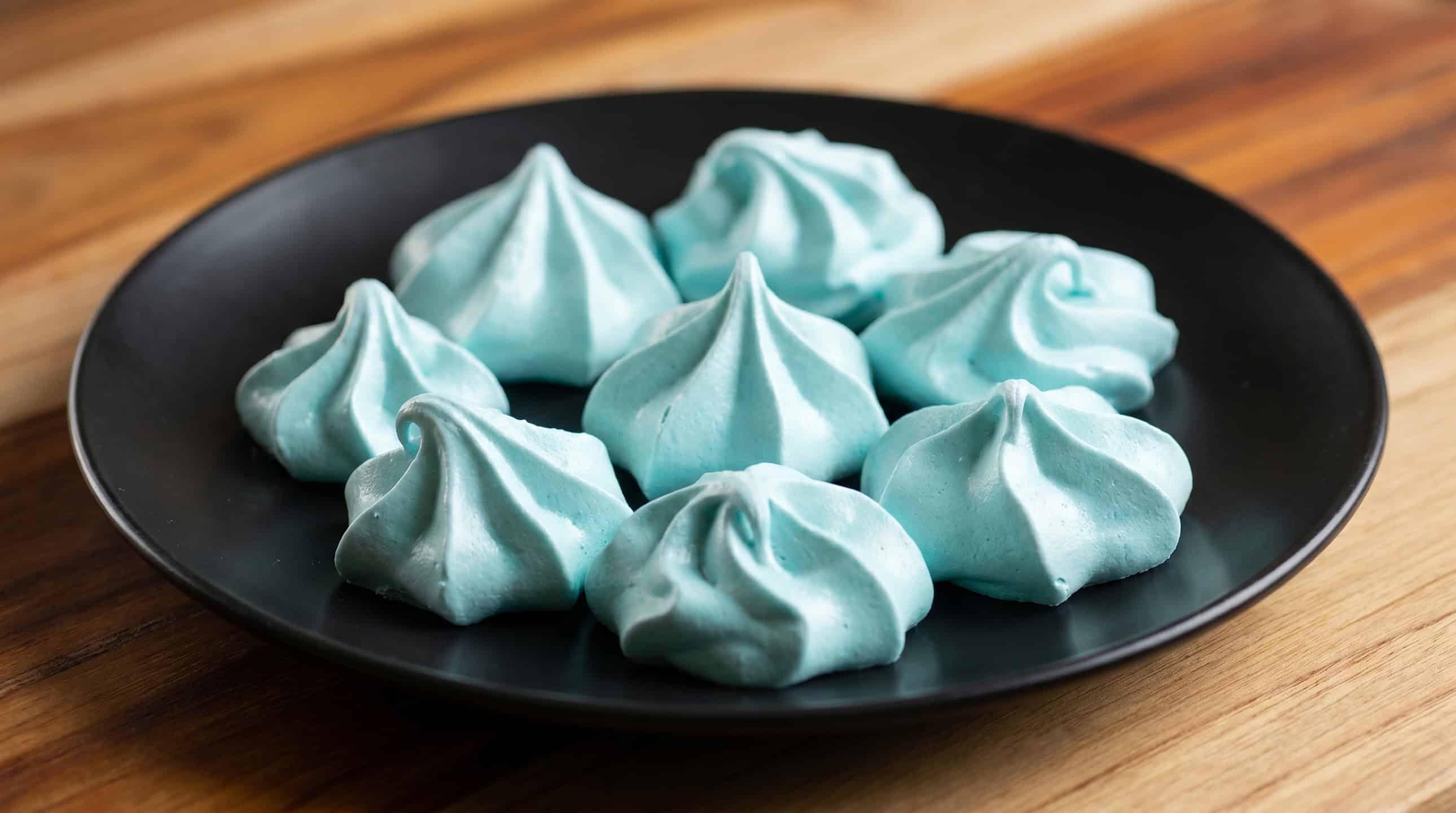 Delicate pastel merengues plated on matte black